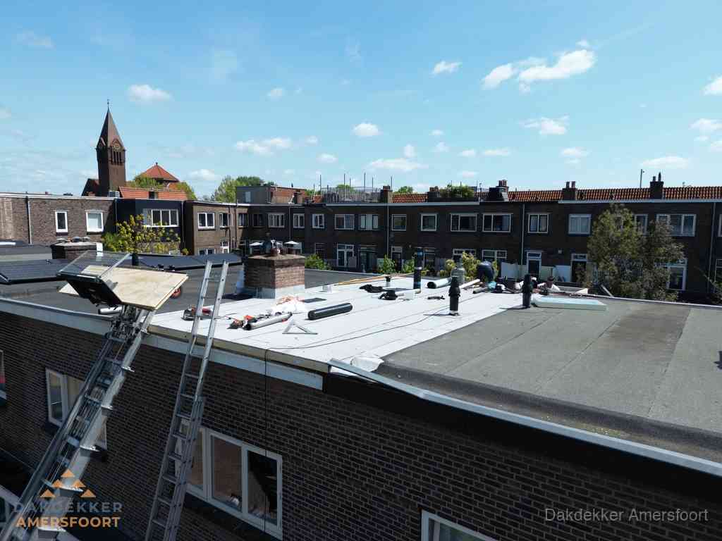 Dakdekkers aan het werk op plat dak in Amersfoort
