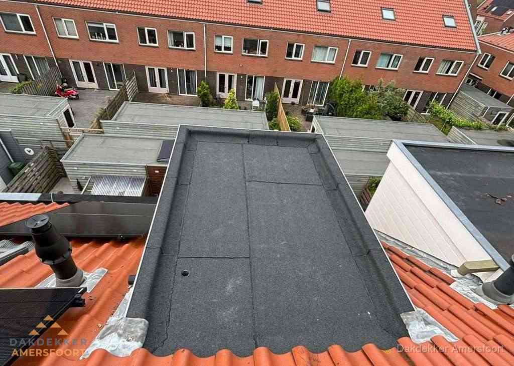 Plat dak met bitumen bedekking naast dakkapel in Amersfoort