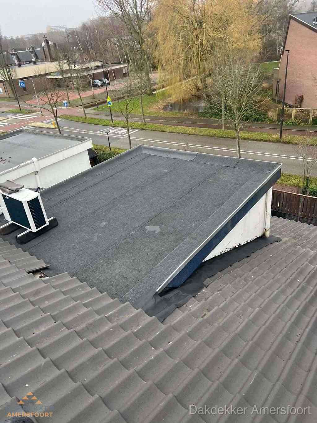 Plat dak met bitumen dakbedekking naast schuin pannendak in Amersfoort