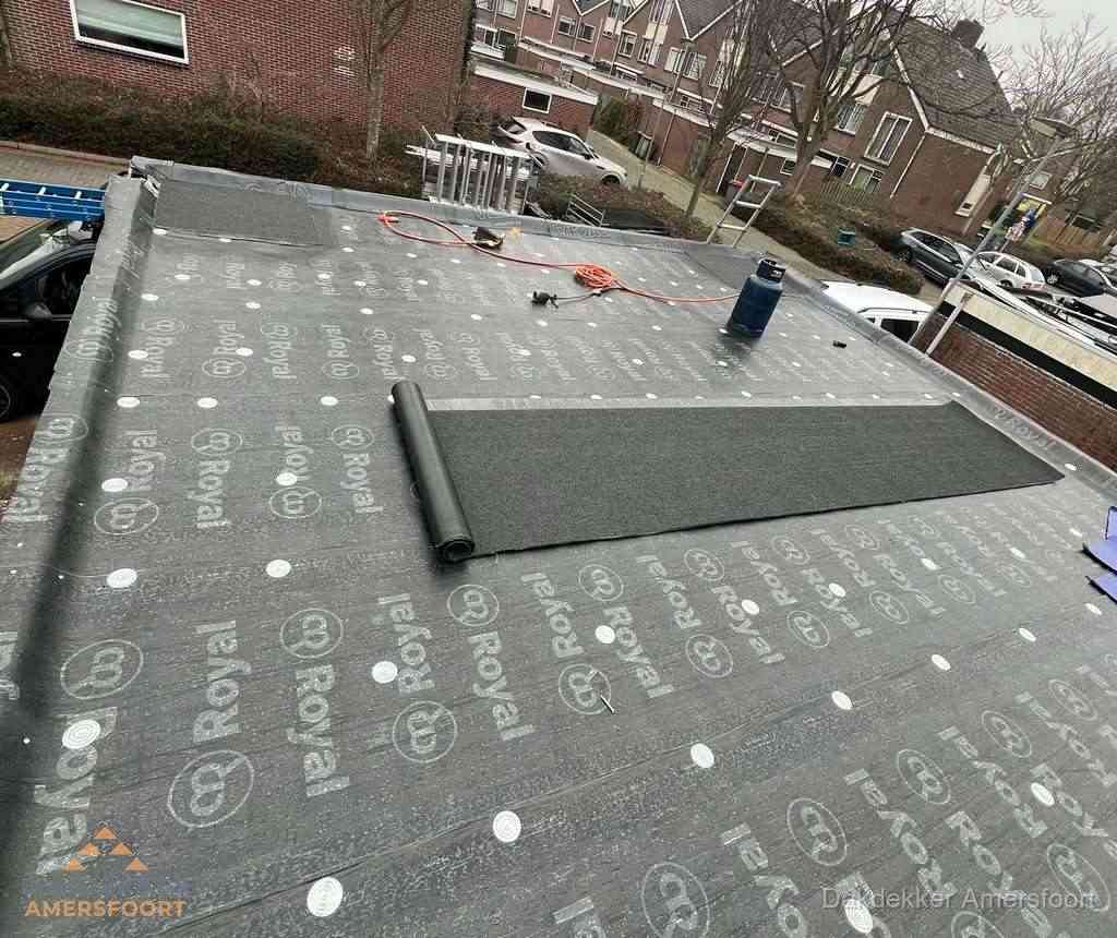 Dakdekker aan het werk met gasbrander op plat bitumen dak in Amersfoort